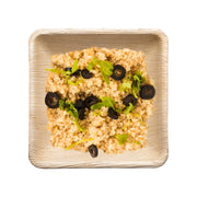 Square palm leaf bowl filled with a healthy quinoa and vegetable mix, ideal for eco-conscious dining