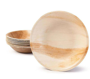 A stack of round, shallow, eco-friendly biodegradable plates in light brown, featuring subtle natural wood grain patterns. The top plate is placed upright, leaning against the others, showcasing its design prominently.