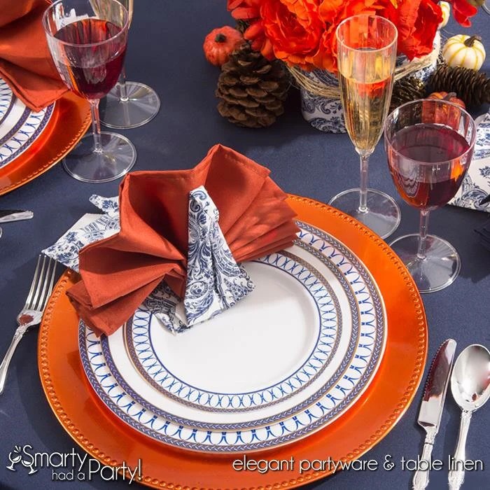 A festive Thanksgiving party ideas featuring elegant plastic plates alongside coordinating napkins, silverware, and drinkware.