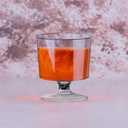 2 oz. Clear Round Plastic Disposable Mini Wine Glasses featured at a modern event alongside appetizers and cocktails