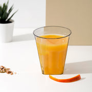 2 oz. Clear Square Bottom Disposable Plastic Shot Cups used during a modern celebration with appetizers and drinks