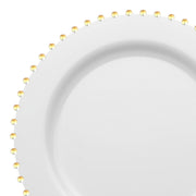 The White with Gold Pearl String Round Disposable Plastic Dinner Plates (10”) feature a elegant round shape, a raised border adorned with a gold pearl string around its edge, and a plain, smooth interior offering both style and simplicity.