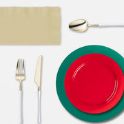 A cozy indoor holiday dinner featuring Feliz Navidad plastic plates and tumblers.
