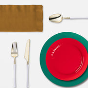 A cozy indoor holiday dinner featuring Feliz Navidad plastic plates and tumblers