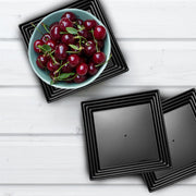 Black disposable serving tray with groove rim in a formal dining setup, presenting hors d'oeuvres