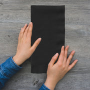 Black velvet paper dinner napkin elegantly placed on a plate, 16 x 16 inches, from a bulk pack of 600.