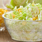 Clear Floral Round Disposable Plastic Dessert Bowl (6 oz.) elegantly presented with crisp lettuce and sweet corn kernels.