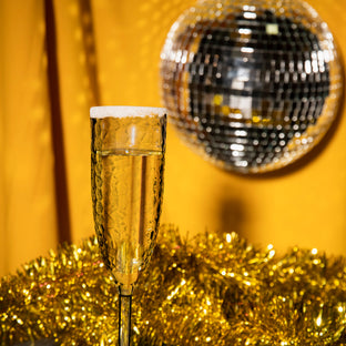 Close-up of 8 oz. Crystal Disposable Plastic Champagne Flutes in a vibrant setting, ready to serve beverages in style