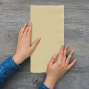 Close-up of ivory paper napkin showcasing soft embossed texture, unfolded to 16 x 16 inches, from 600-count case.