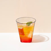 Cocktail station display showing 2 oz. Clear Square Bottom Disposable Plastic Shot Cups with wine, snacks, and ambient light