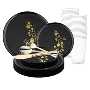 Complete place setting featuring black with gold floral plastic dinnerware and clear tumbler