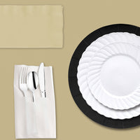 Cozy candlelit dinner with black chargers and white plates.