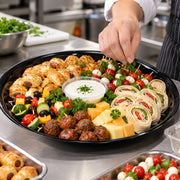 Deep black serving tray in sturdy plastic, ideal for buffet lines loaded with charcuterie, fruit, or pastry selections.