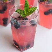 Durable 10 oz clear disposable plastic cups with a unique square bottom, elegant and perfect for serving cocktails or desserts