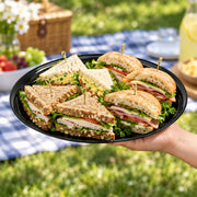 Durable round black tray in heavyweight plastic, great for canapés, mini desserts, and late-night snack stations.