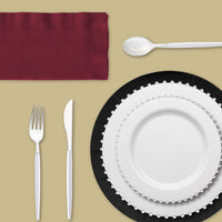 Elegant burgundy napkins providing contrast against silver-accented dinnerware.