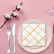 Elegant white beverage napkins adorned with gold diamond accents, ideal for upscale entertaining and event décor