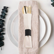 Fancy gold plastic cutlery wrapped in white napkin rolls, adding a sophisticated touch to weddings and banquets, set for 100 guests.