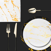 Flat lay showcasing marble charger with gold-rimmed plate and coordinated cutlery.