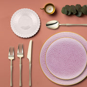 Gold-rimmed pink hammered plates add elegance and shimmer to festive occasions.