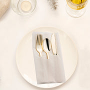 Gold plastic cutlery set, including a fork, knife, and spoon, neatly arranged in a white napkin pocket for easy table setup.