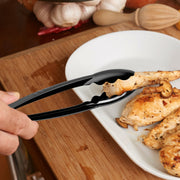 Guest lifting a pastry with black heavyweight PP food serving tongs at a self-serve station, sanitary disposable tongs for catered events.

