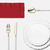 Guests enjoy Thanksgiving dinner served on clear lotus plates and gold-rimmed tumblers under warm lights..