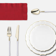 Guests enjoy Thanksgiving dinner served on clear lotus plates and gold-rimmed tumblers under warm lights.
