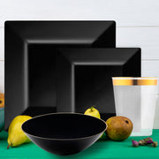 Guests enjoying meals on sleek black square plates at a chic dinner party.
