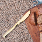 High-quality metallic gold plastic knives with a polished finish, perfect for enhancing table settings at special events