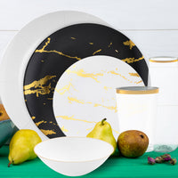 Overhead view of black charger plate layered with gold and white dinner plate.