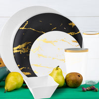 Overhead view of black charger plate layered with gold and white dinner plate