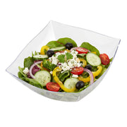 Premium 32 oz clear wavy square plastic bowl shown at an angle, highlighting the sculpted wave rim and deep square well for family-style serving.