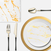 Reception dinner setup with sparkling glassware, gold-trimmed plates, and matching cutlery under warm lights.