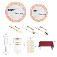 Red and gold chord rim plates placed on a burgundy table with gold-accented tumblers.
