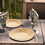 Round Palm Leaf 5" Pastry Plates set on a rustic table with wooden accents, ideal for nature-inspired events