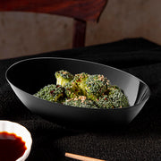 Sleek black oval plastic serving bowl filled with steamed broccoli, elegant disposable dinnerware for modern party catering.