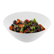 A vibrant salad featuring halved cherry tomatoes, black beans, chopped red onions, and garnished with fresh parsley leaves is served in a Solid White Organic Round Disposable Plastic Bowl (100 oz.) from the Kaya Collection. The colorful ingredients contrast beautifully against the eco-friendly bowl, creating an appetizing visual appeal.