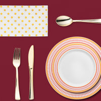 Stylish indoor dinner scene with regal tones and upscale disposable plates and flutes.