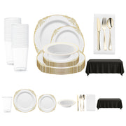Stylish spring disposable dinnerware set with white and gold plates, gold cutlery, and classic black and white table accents.