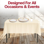 Thanksgiving table set with burgundy-gold rim plates and tumblers, styled with candles and pumpkins.