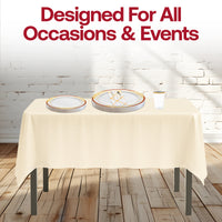 Thanksgiving table set with burgundy-gold rim plates and tumblers, styled with candles and pumpkins.