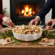 Upscale white disposable plastic bowl with gold rim featuring a fresh greek salad, perfect for elegant party catering.