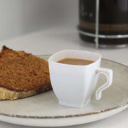 White disposable square mini tea cups, 2 oz., made of durable plastic for easy single-use convenience at parties and gatherings