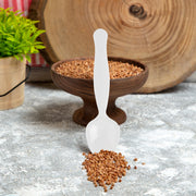 White plastic serving spoons resting beside chafing dishes on a buffet line, clean disposable serveware for weddings, showers, and holiday parties.

