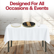White tablecloth and gold-rimmed dishes in the Dear Santa Set shine in a candlelit setting