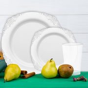 flat lay of silver fancy plates, gold tablecloth, and ivory napkins at a baby shower brunch.